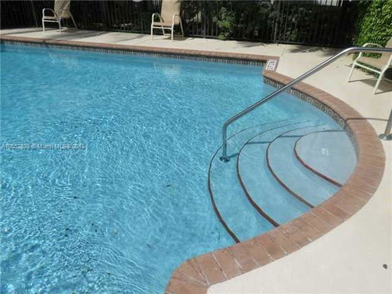 Outdoor swimming pool with steps and handrail.
