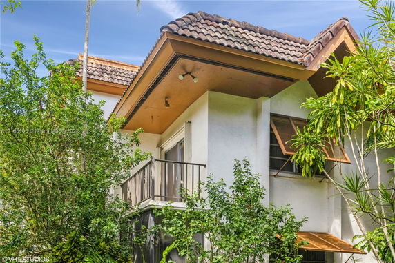 Front view of a house with decorative roof tiles and a small balcony.