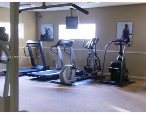 Indoor gym area with exercise equipment and wall posters.