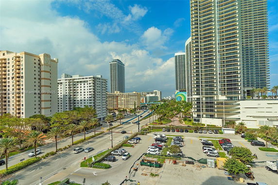 View of multiple high-rise buildings and a road with vehicles in an urban area.