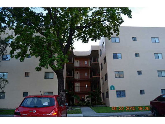 Front view of a multi-story apartment building with balconies.