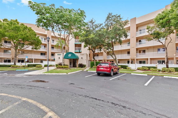 Front view of a multi-story apartment building with a covered entrance.