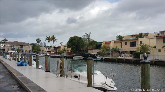Waterfront view with houses and docked boats.