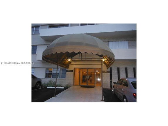 Front view of a building entrance with an arched canopy.