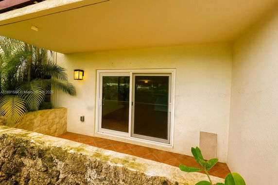 Front view of a house with a sliding glass door and a covered patio.