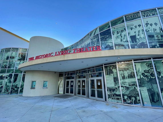 Front view of the historic theater building with large windows displaying images.