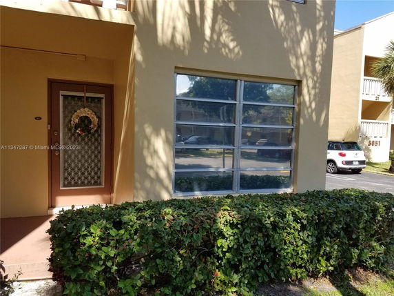 Front view of an apartment entrance with glass windows and a decorative door.