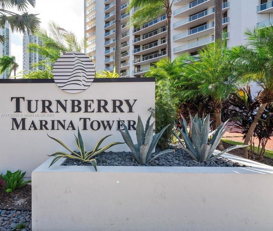 Front view of a multi-story building with a sign labeled Turnberry Marina Tower.