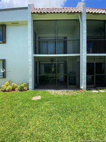 Front view of a two-story house with screened balconies.