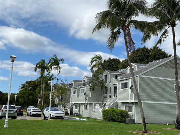 Front view of multi-story residential buildings with parking spaces.