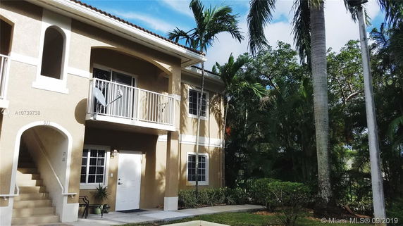 Front view of a two-story building with a staircase and balcony.