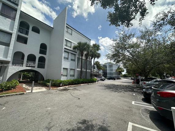 Front view of a multi-story residential building with arched balconies.