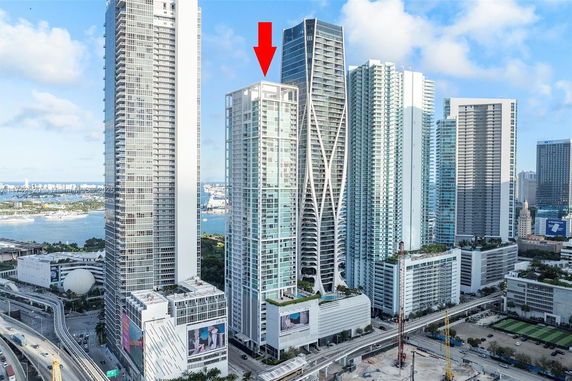 Elevated view of a high-rise building surrounded by other tall buildings in an urban setting.
