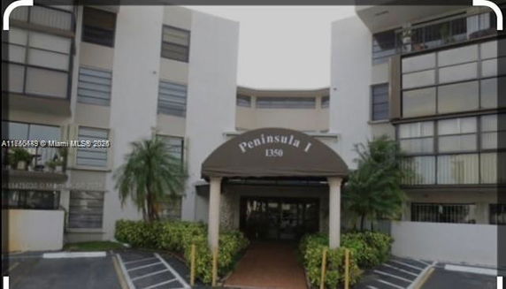 Front view of a multi-story residential building with an entrance canopy labeled Peninsula 1.