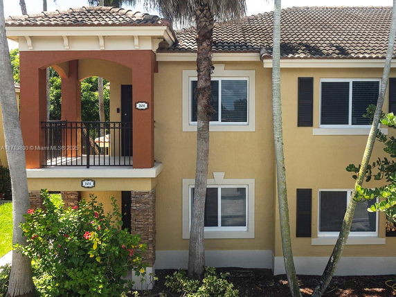 Front view of a two-story house with a balcony and tiled roof.