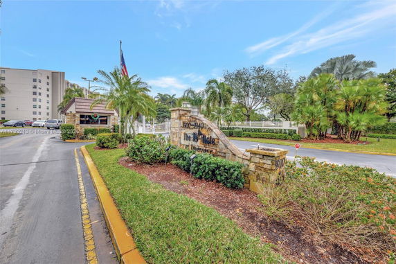Front view of a residential complex entrance with signage and landscaping.