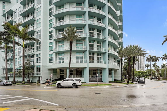 Front view of a modern multi-story building with rounded balconies.