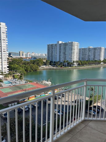 View from a balcony overlooking a waterway and several high-rise buildings.