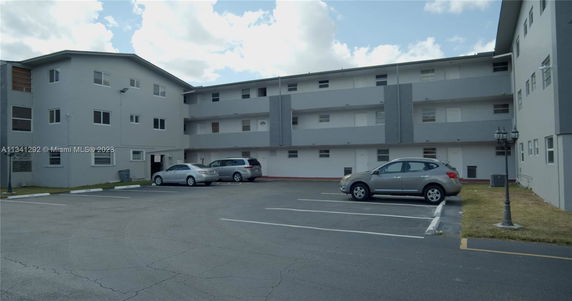 Parking area in front of a multi-story building.