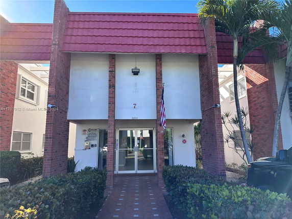 Front view of a two-story building with red brick pillars and a red tiled roof.