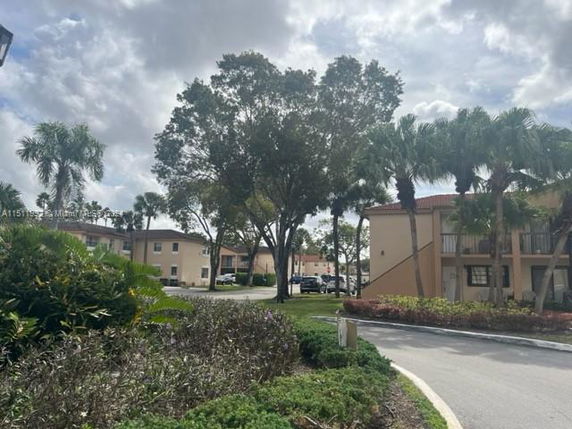 View of residential buildings with a tree-lined street.