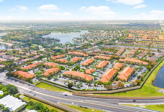 Panoramic view of a residential area with multiple buildings, roads, and a lake.