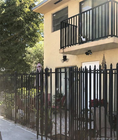Front view of a two-story house with a balcony and iron fencing.