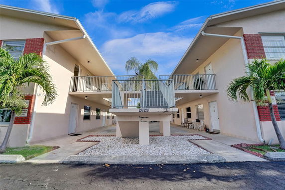 Front view of a two-story condo building with a connecting balcony.