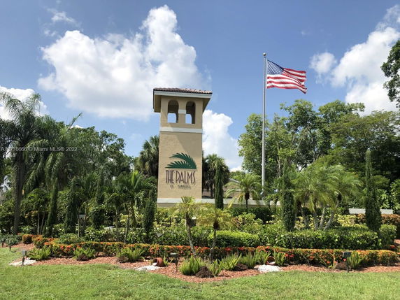 Front view of a tower structure with an American flag at 'The Palms' entrance.