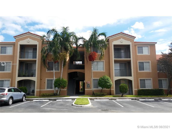 Front view of a three-story apartment building with balconies.