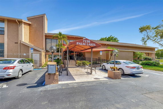 Front view of a building with a labeled canopy entrance and adjacent parking area.