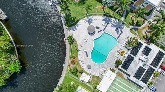 Aerial view of a rooftop with solar panels next to a pool and surrounding leisure area.