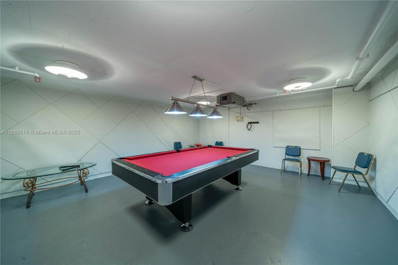 Room with a pool table and chairs