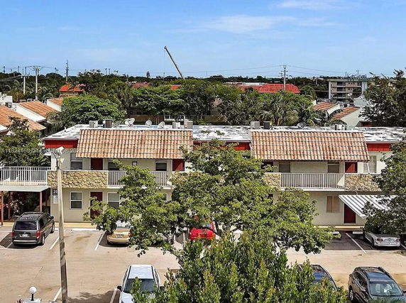 View of a residential area with two-story buildings and parking spaces in front.