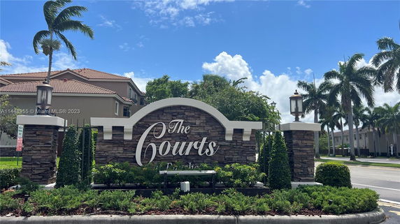 Front view of a residential building entrance with a sign reading 'The Courts'.