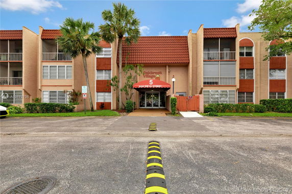 Front view of a multi-story residential building with a red awning.