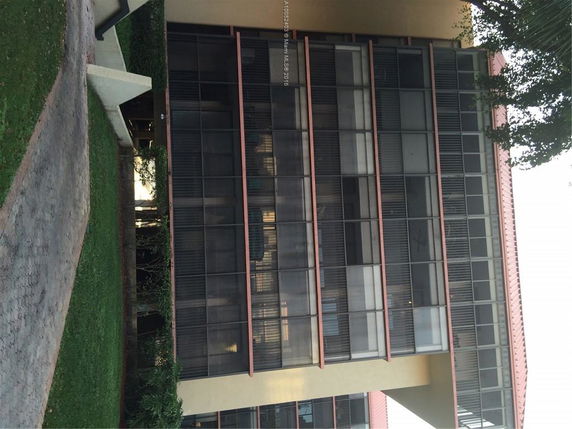 Front view of a multi-story building with large windows.