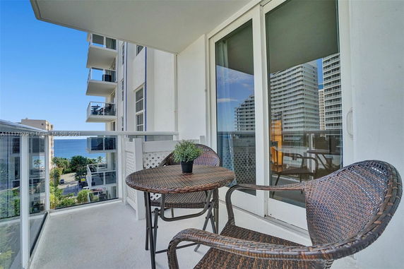 Balcony view showing multiple high-rise buildings and the ocean.