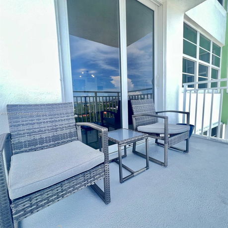 Balcony with outdoor seating and view of surrounding areas.