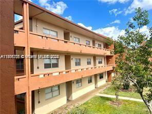 Front view of a three-story apartment building with multiple balconies.