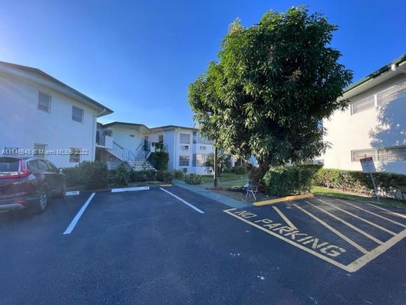 Outdoor parking area in front of a multi-story residential building.