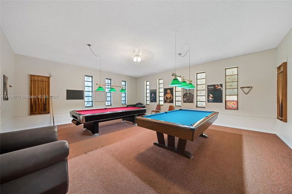 Interior of a recreation room with two pool tables and wall decorations.
