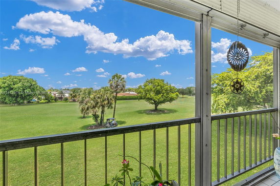 View of surrounding green landscape with trees seen from a balcony.