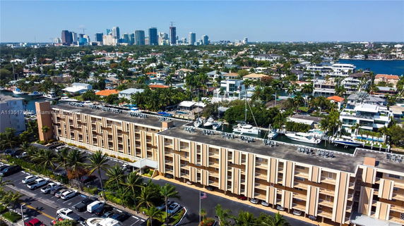 Aerial view of a multi-story building with surrounding residential and city areas.