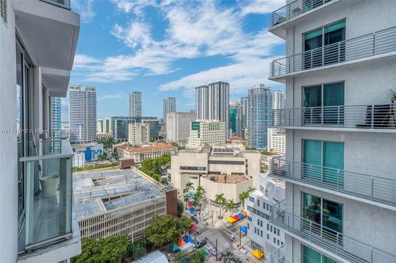 View of surrounding cityscape from a high-rise building, showcasing multiple skyscrapers and urban structures.