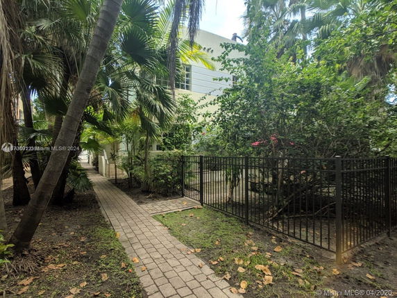 Building view surrounded by lush greenery and a walkway.