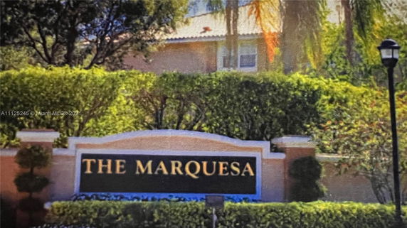 Entrance sign for The Marquesa with landscaping around.