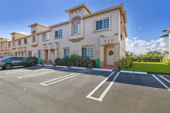 Front view of a two-story townhouse with an attached parking area.