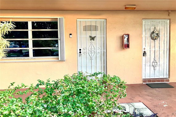 Front view of a house with a window and two metal security doors.