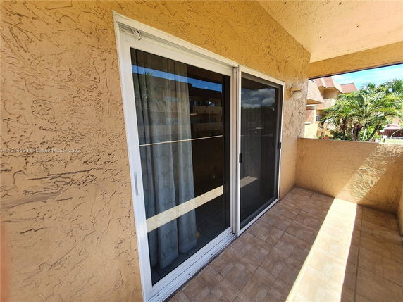 Balcony view of a building exterior with sliding glass doors.